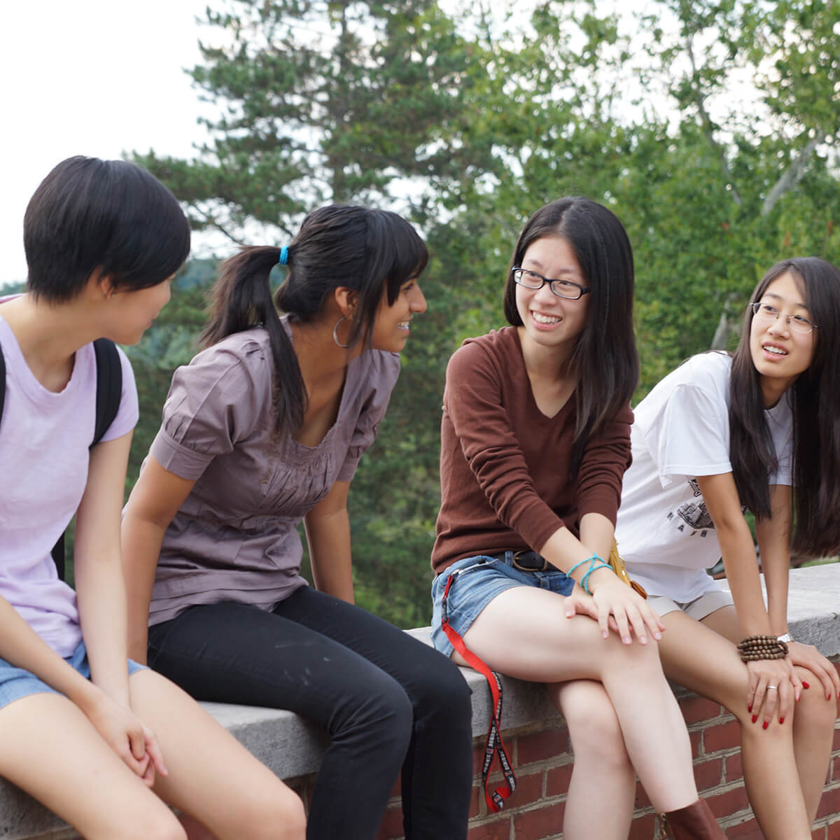 International students sitting on Denison's Academic Quad talking.