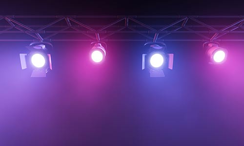 A photo of four stage lights against a dark background