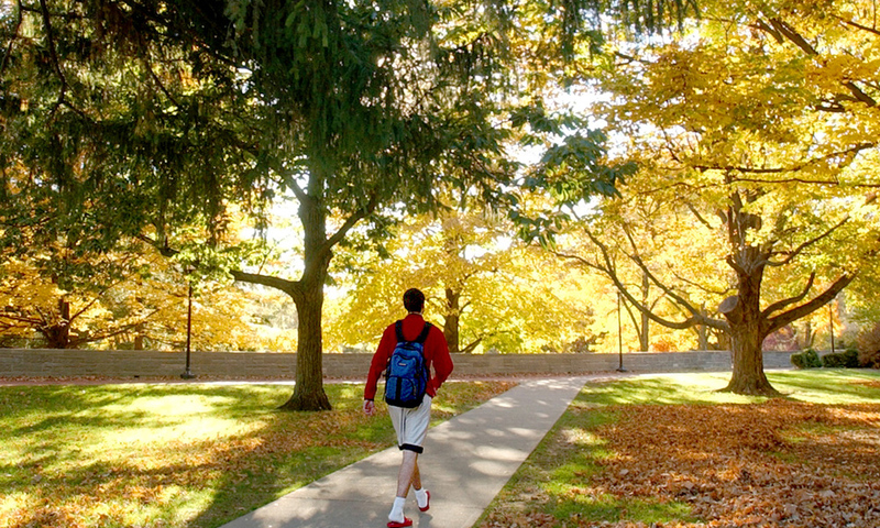 Student walking as the sun sets
