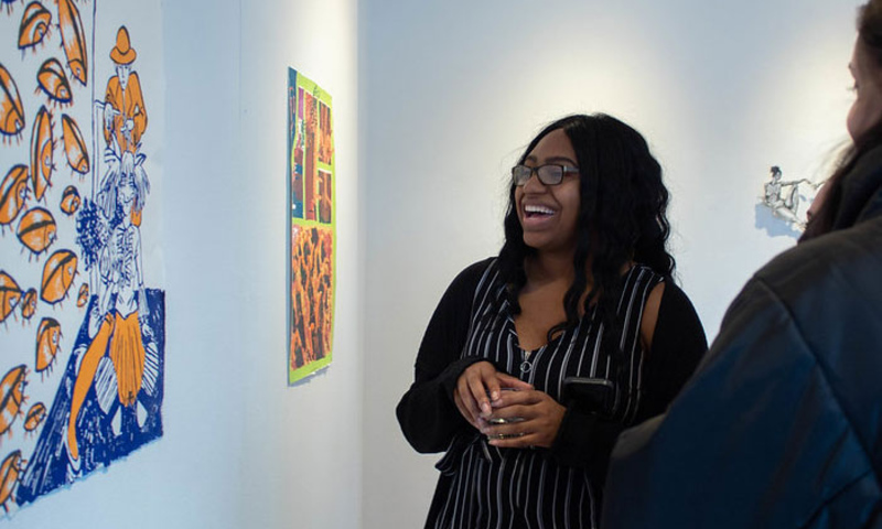 Student smiling at art display