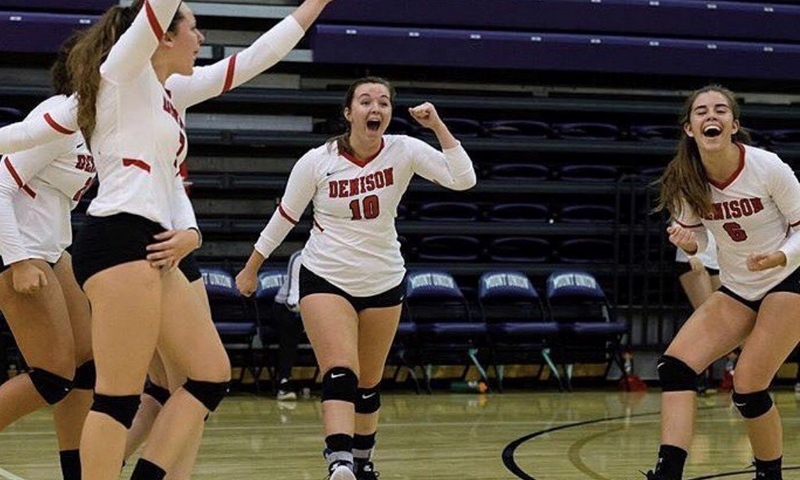 Julia Miller and teammates celebrate during a volleyball match