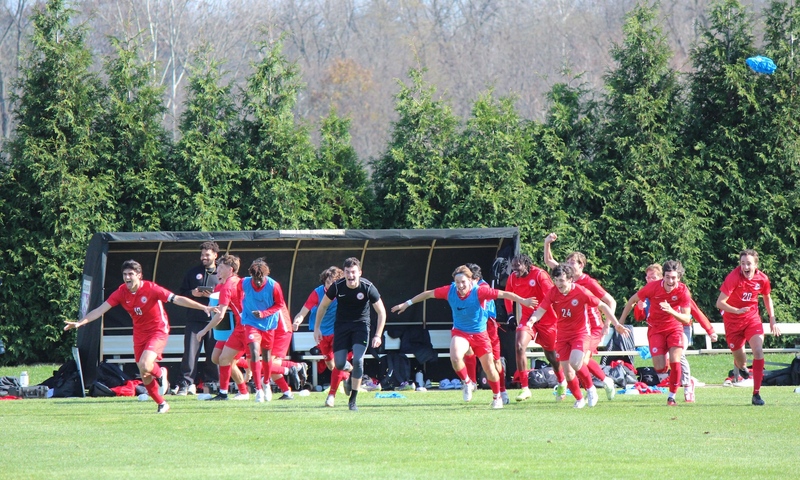 Members of the men’s soccer team run off the bench to celebrate a conference tournament championship. (Shannon O’Brien)