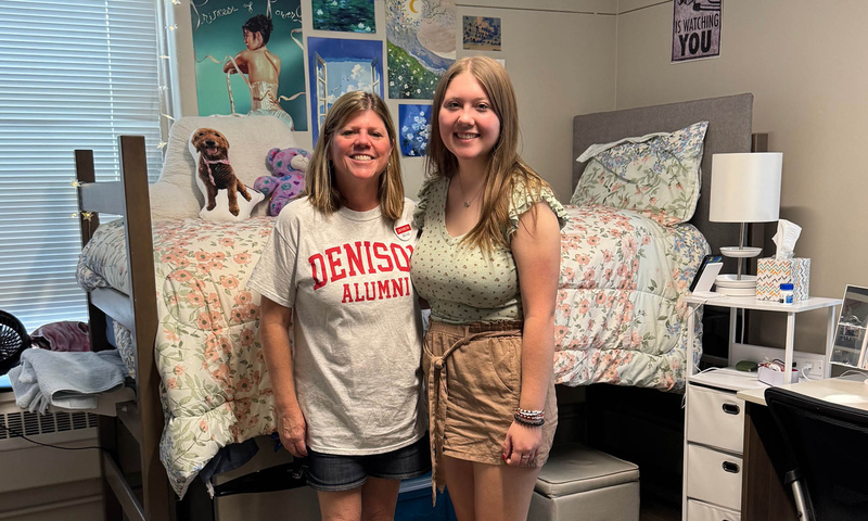 Michele Walton Hoehn '89 with her daughter Kare '29 standing in a college dorm room.