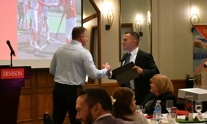 Denison coach Mike Deegan greets former Denison pitcher Matthew Zmuda at the First Pitch Banquet.