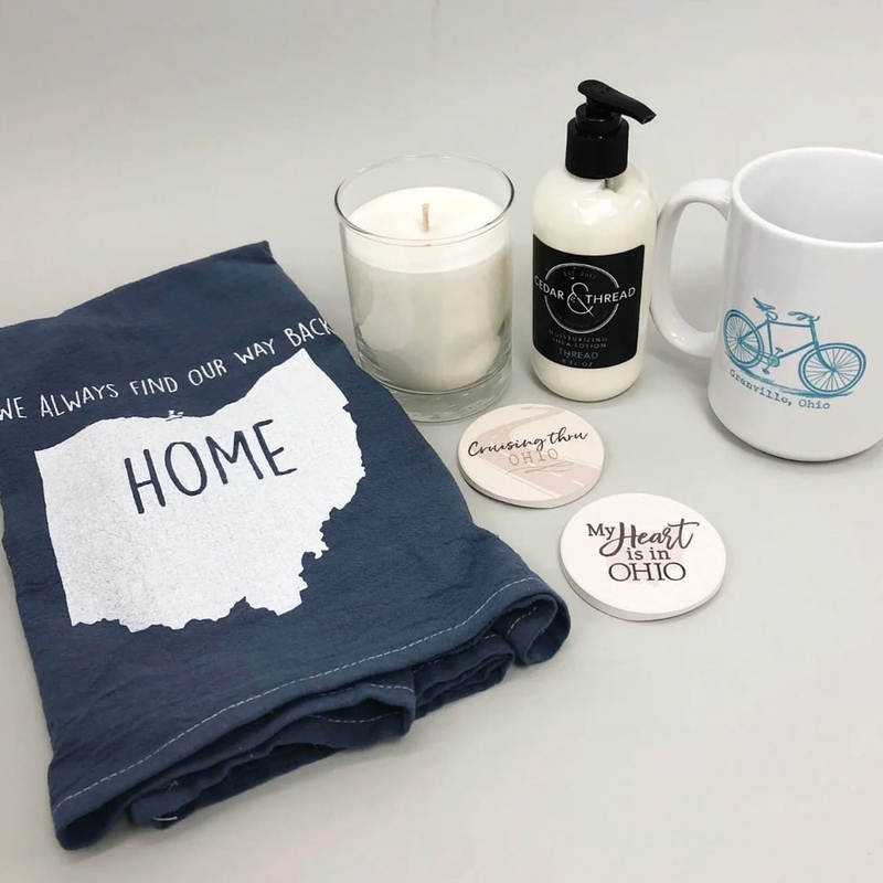 Items from Granville that include a dish cloth, coasters, candle, lotion and a mug