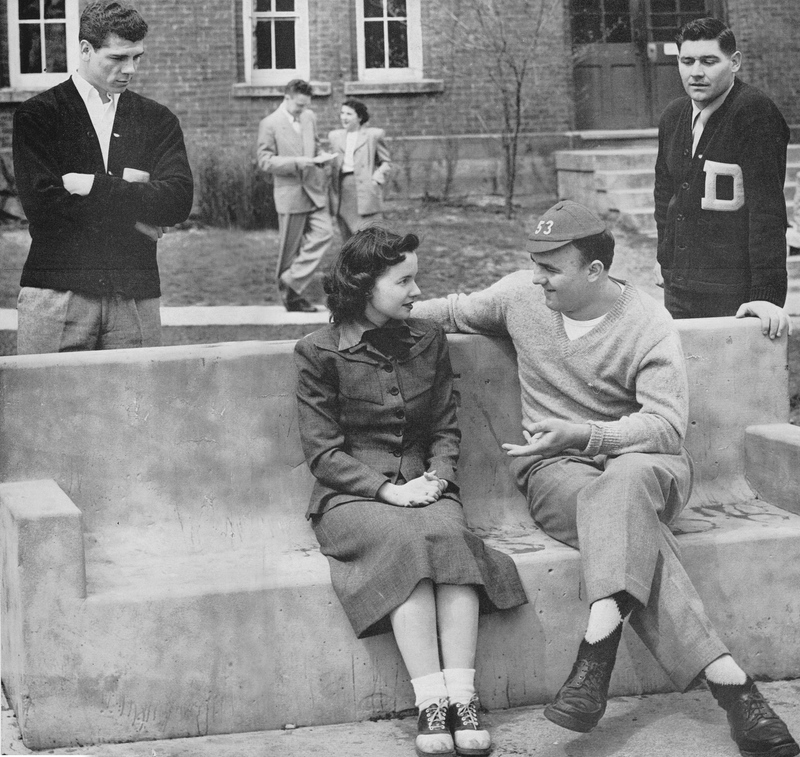 students sitting on and standing near the 1905 bench