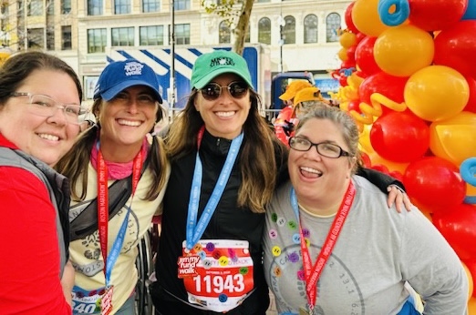 From left: Julie Wilson, Krista Lehde, Kate Armbrust, and June Torres, all Class of 2006, in Copley Square at the finish line of the Boston Marathon course on Oct. 2, 2022.