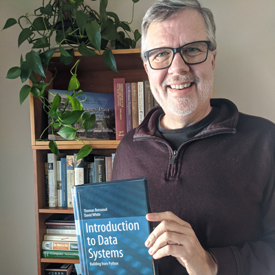 Associate Professor Thomas Bressoud with the new textbook “Introduction to Data Systems.”