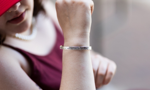 A silver bracelet, inscribed with the quote “She believed she could, so she did”