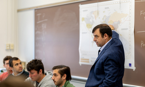 Scott Smitson in a classroom pointing at a map