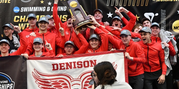 Denison men's swimming and diving team celebrates championship holding NCAA trophy.