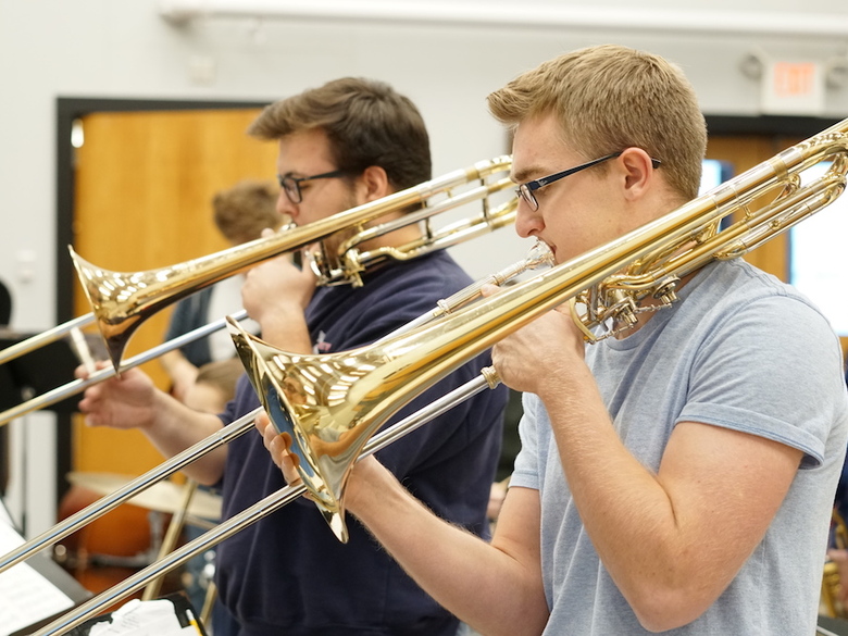 Music students playing trombone in class