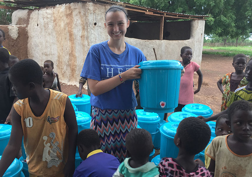 Alexandria Seward '19 among fresh water containers