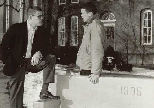 two men standing near the 1905 bench
