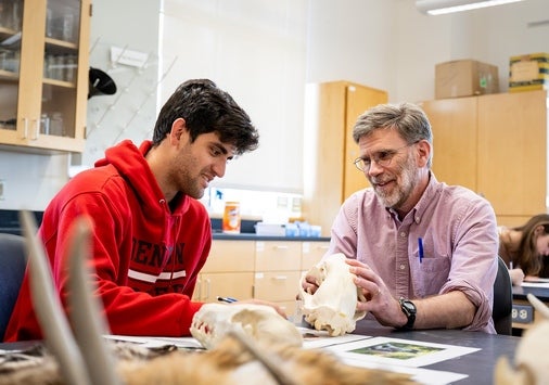 Student with faculty member holding a fossil