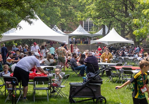 Photo of Denison alumni and families gathered on campus; several large white tents and tables full of people fill the quad.