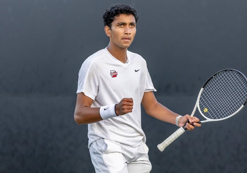 Photo of Kael Shah ’26 on the tennis court in his tennis uniform, holding a tennis racket.