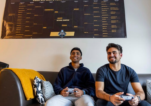 Kael Shah ’26 and Andreas Chapides ’26 sitting on a couch holding video game controllers.