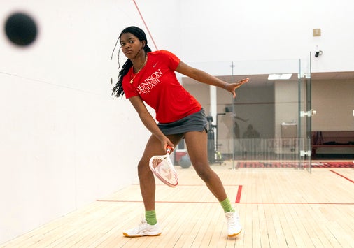 Da’Nerah Chisholm ’29 hits a ball on a squash court at Denison University.