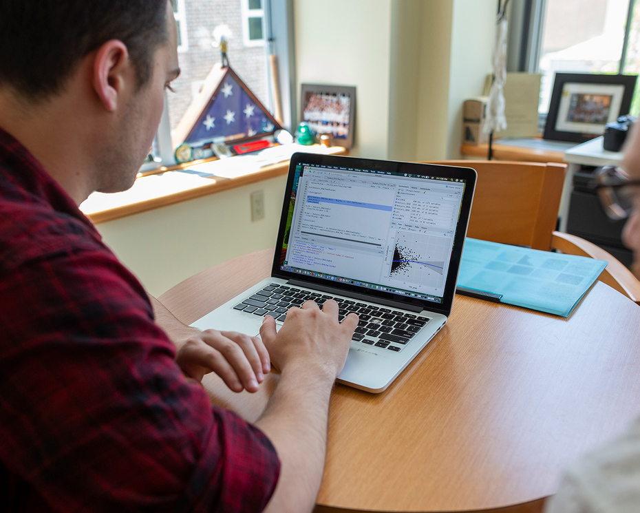 Michael Brady, the outgoing associate director of data analytics, works with a student.