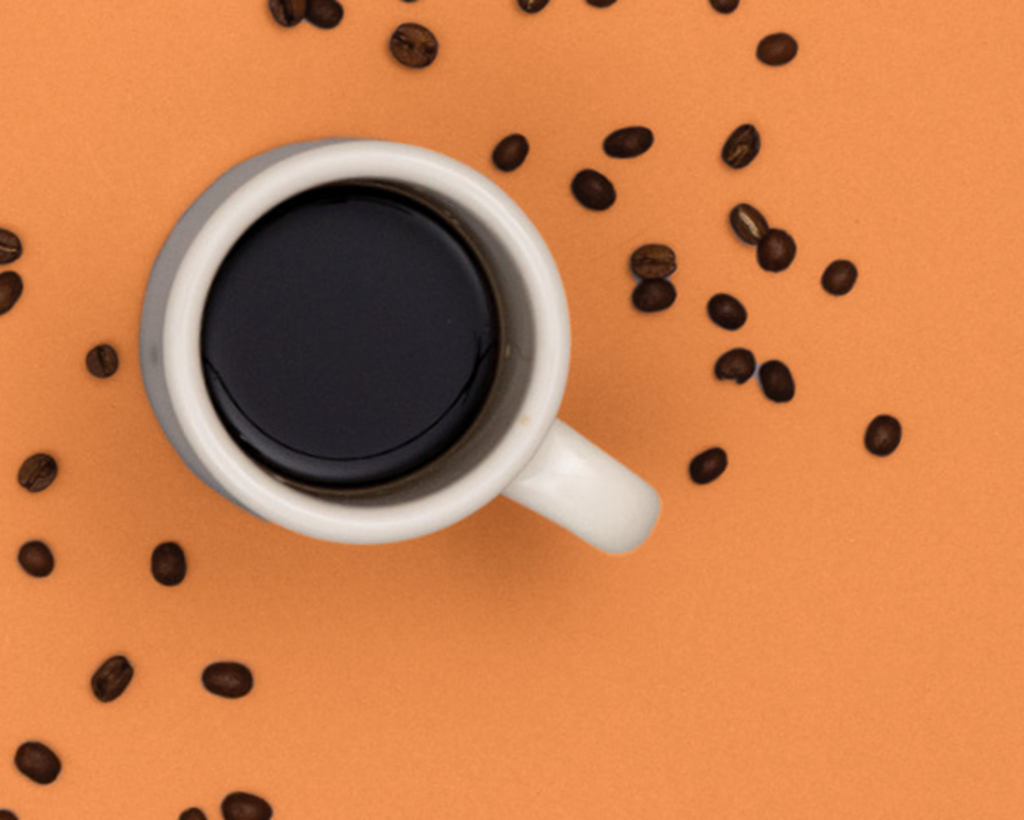 Coffee cup with beans on an orange background