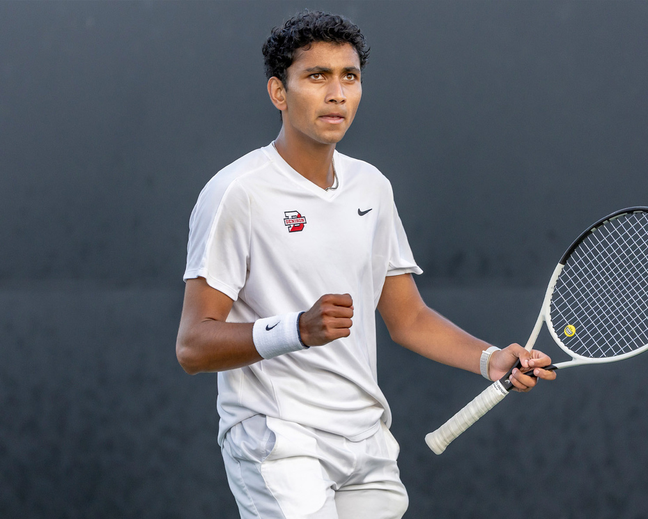 Photo of Kael Shah ’26 on the tennis court in his tennis uniform, holding a tennis racket.