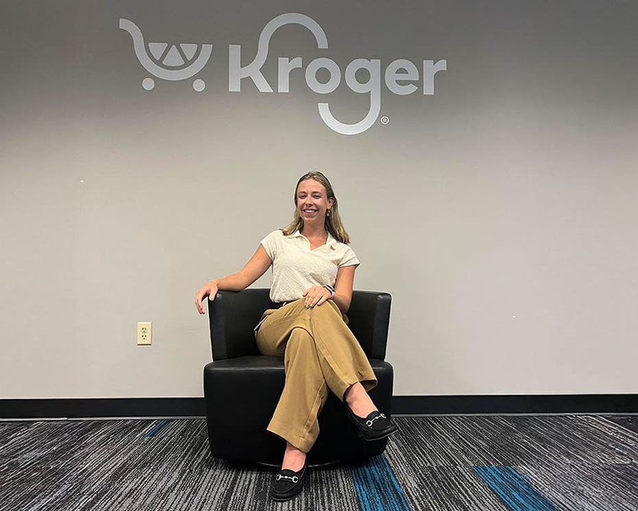 Photo of Jordyn Maurer ’26 sitting in a chair under the Kroger logo.