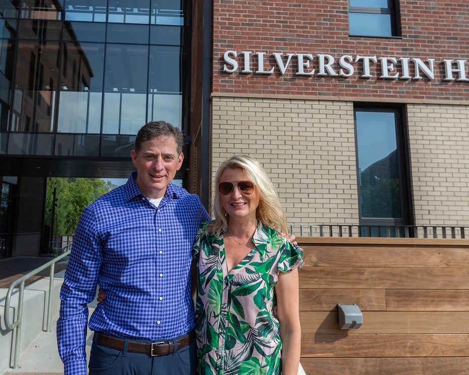 Photo of Jonathan and Natalie Silverstein standing in front of Silverstein Hall.