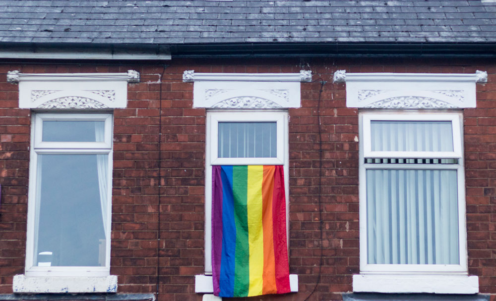 Pride flag hanging out of a window