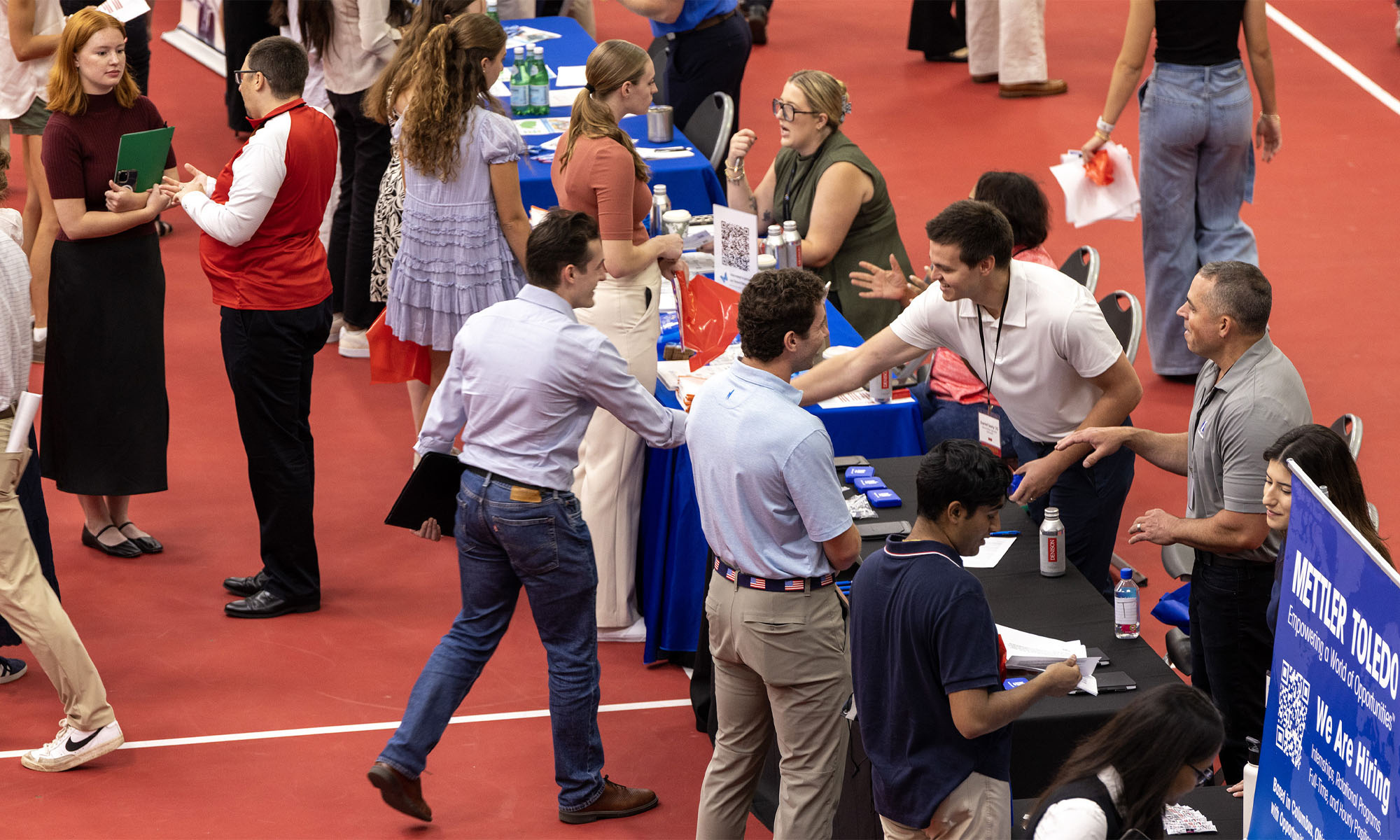 A wide elevated view of students and companies mingling during the Career Expo.