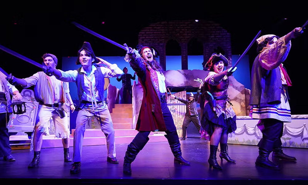 Actors on a stage in pirate costumes.