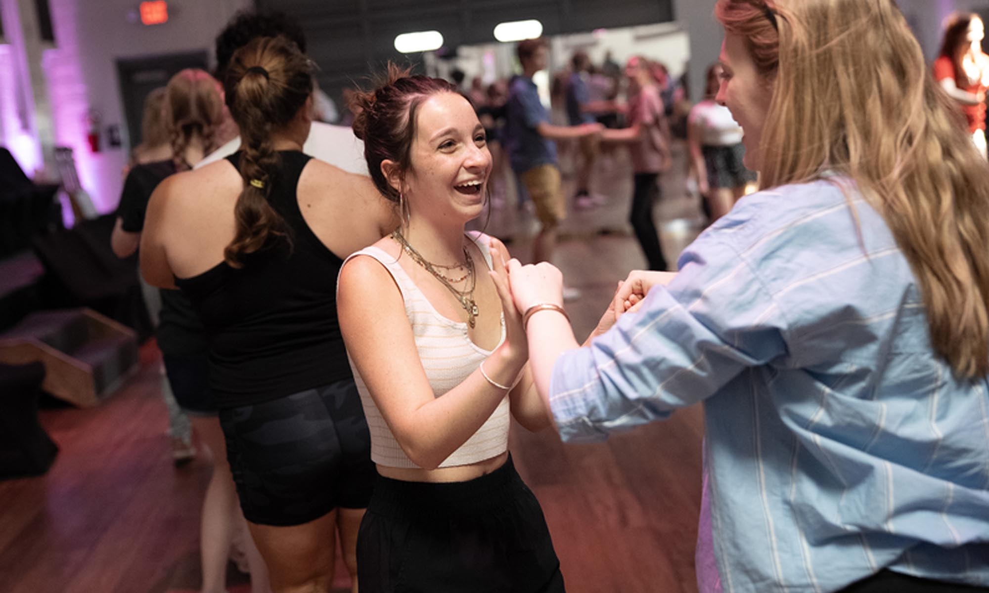 Students practicing dance moves on a dance floor.