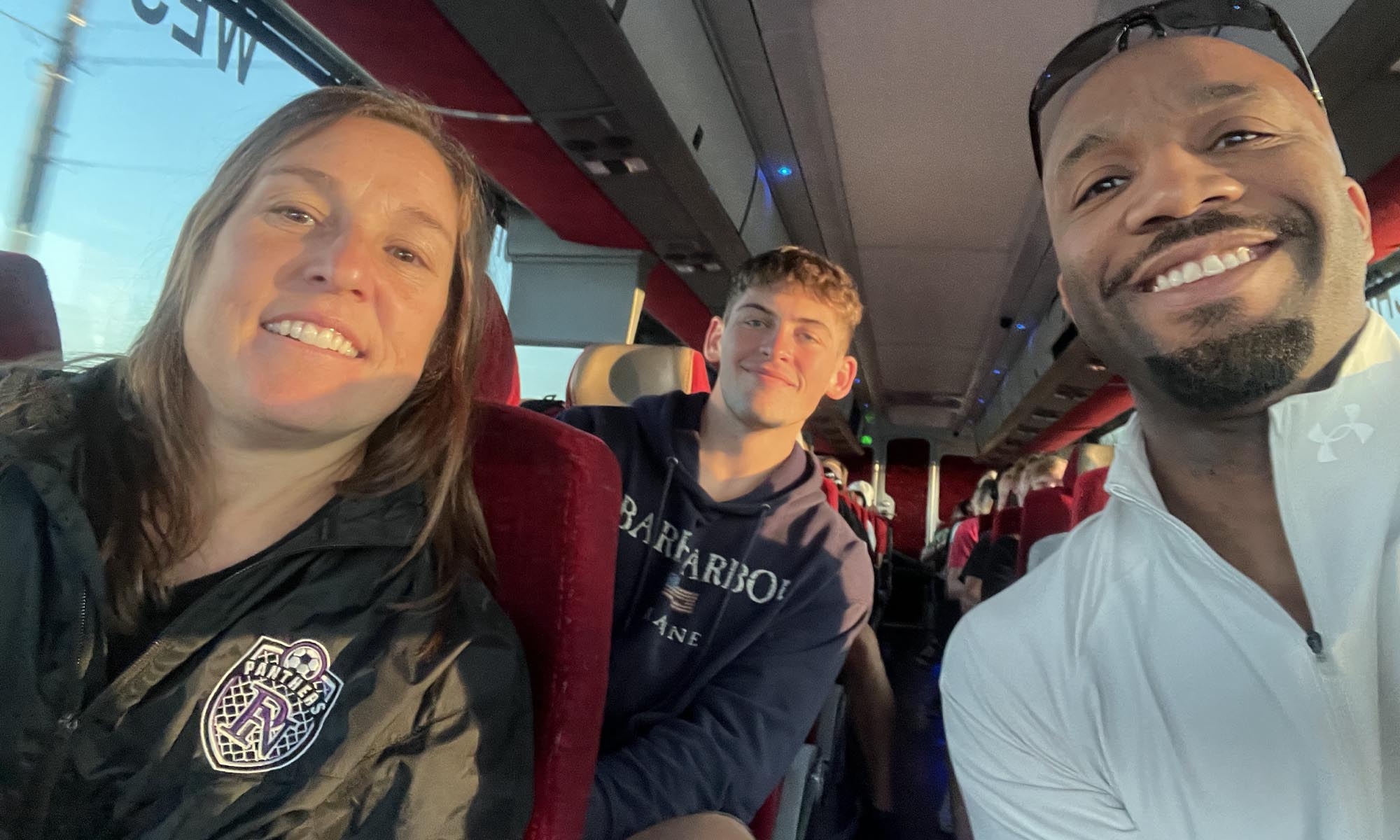 A few students snap a selfie on a bus.
