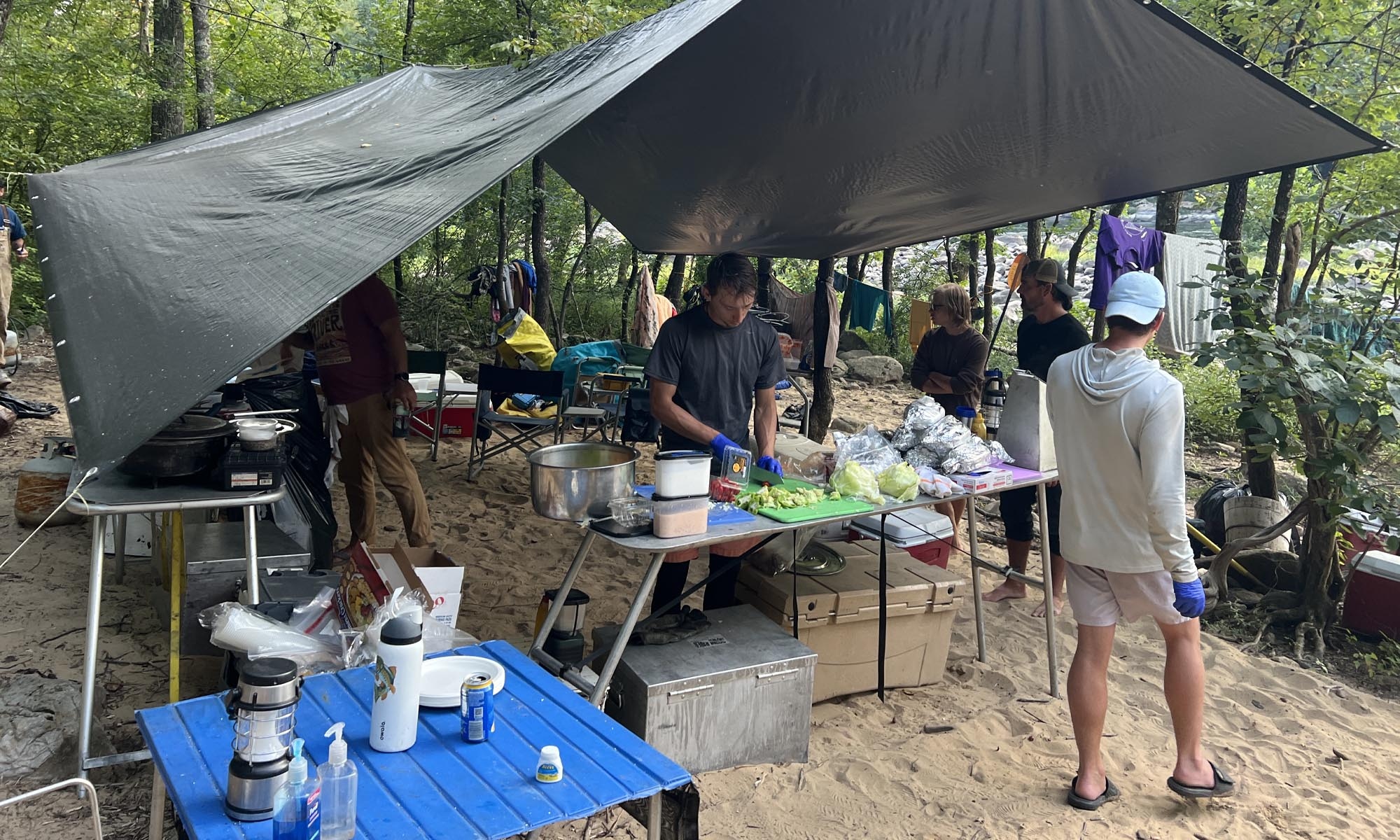 The group prepares meals in a outdoor kitchen.
