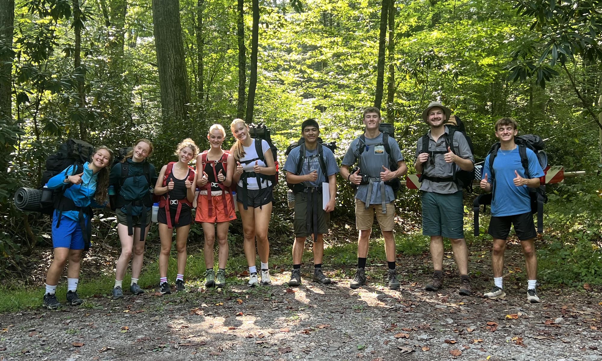 A group of student pose before setting off on a hike.