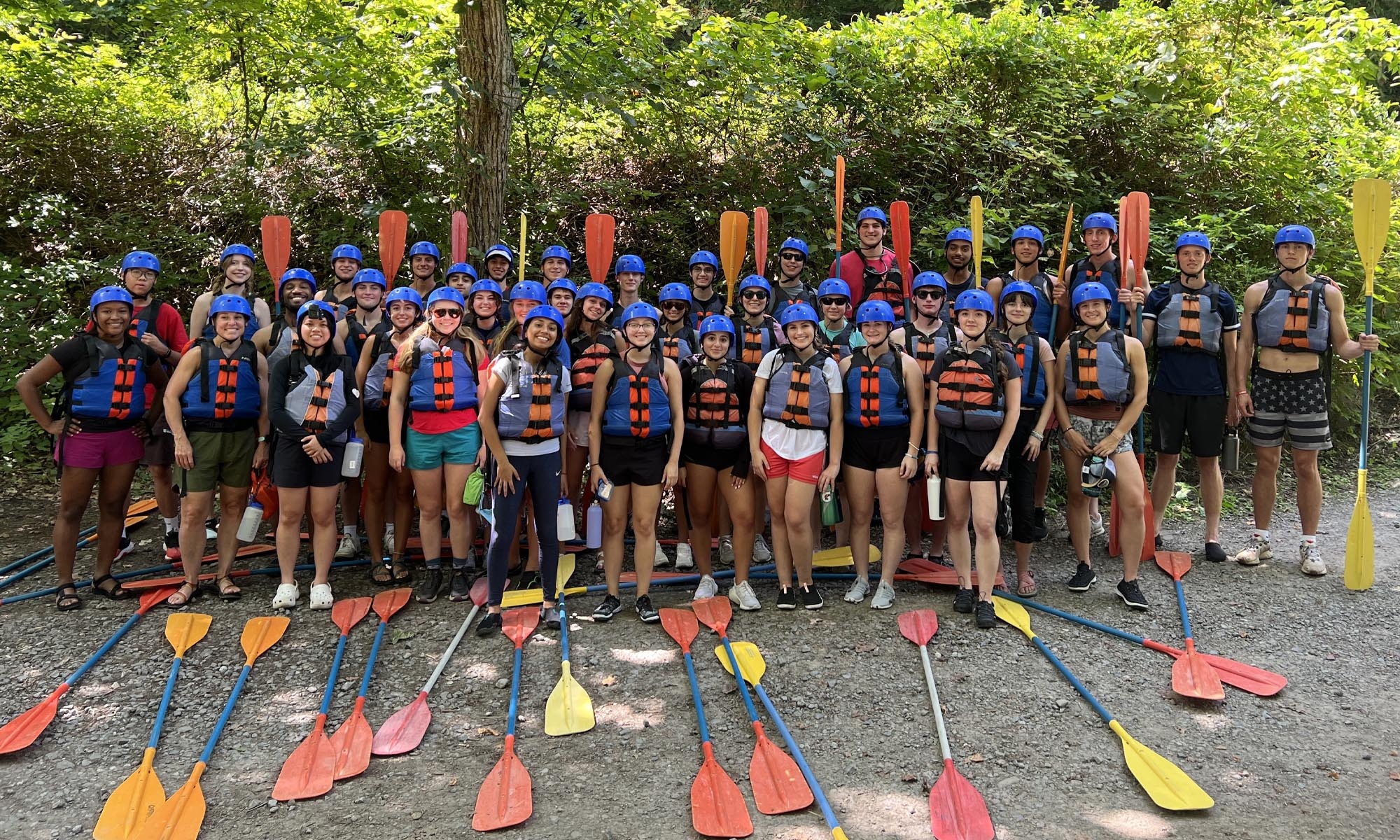 Denison students suited up with life jackets and helmets, posing with their oars, before setting out on their white water rafting adventure. 
