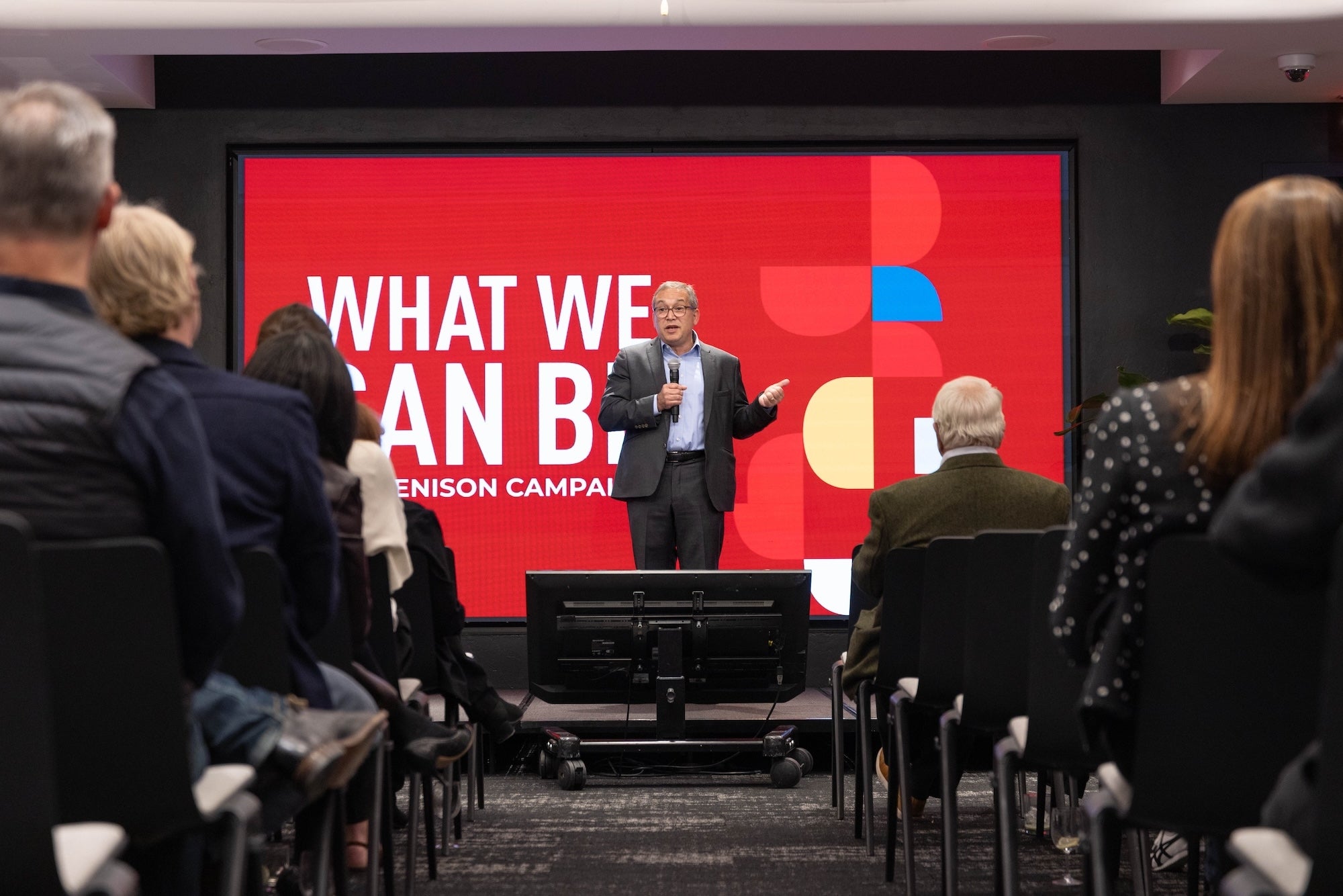 President Weinberg speaks at the NASDAQ campaign event to a large group of listeners seated in chairs