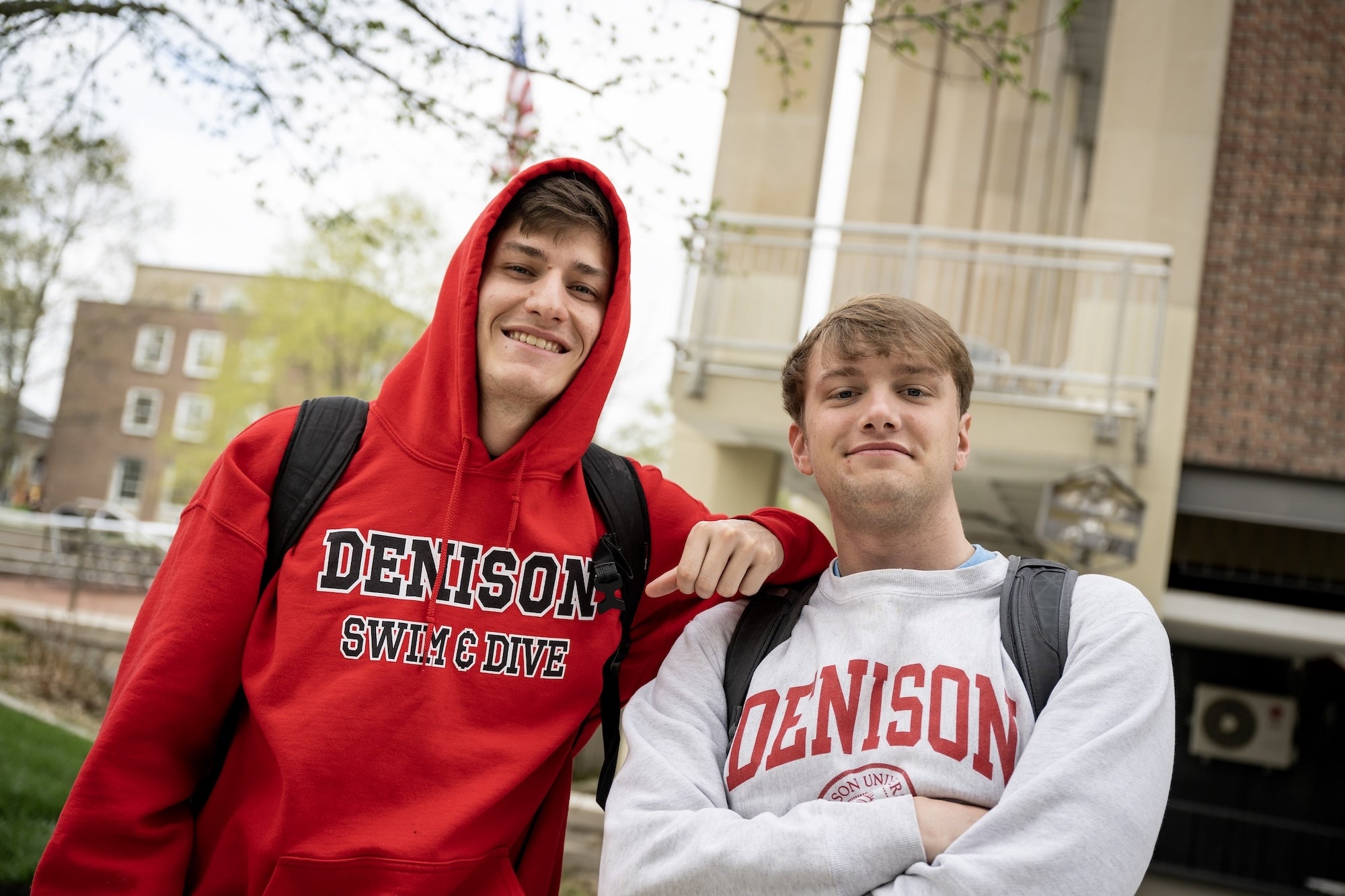 Friends smile and pose with each other on campus