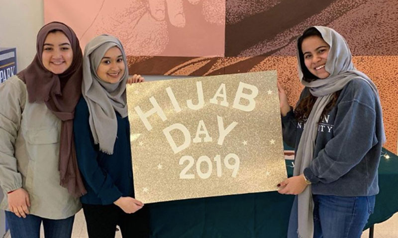 Students holding Hijab Day 2019 sign