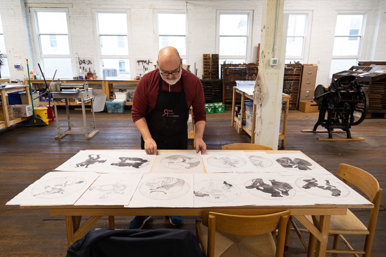 Prof. Ron Abram at a table assembling art