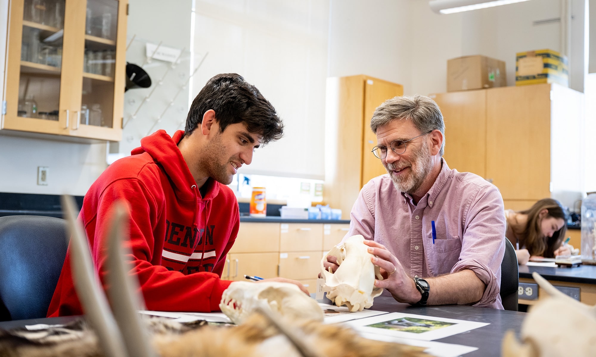 Student with faculty member holding a fossil