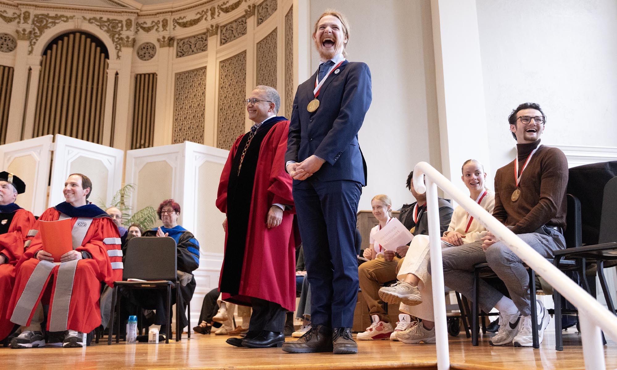 Photo of academic awards stage feature faculty, President Adam Weinberg, and President's Medalists