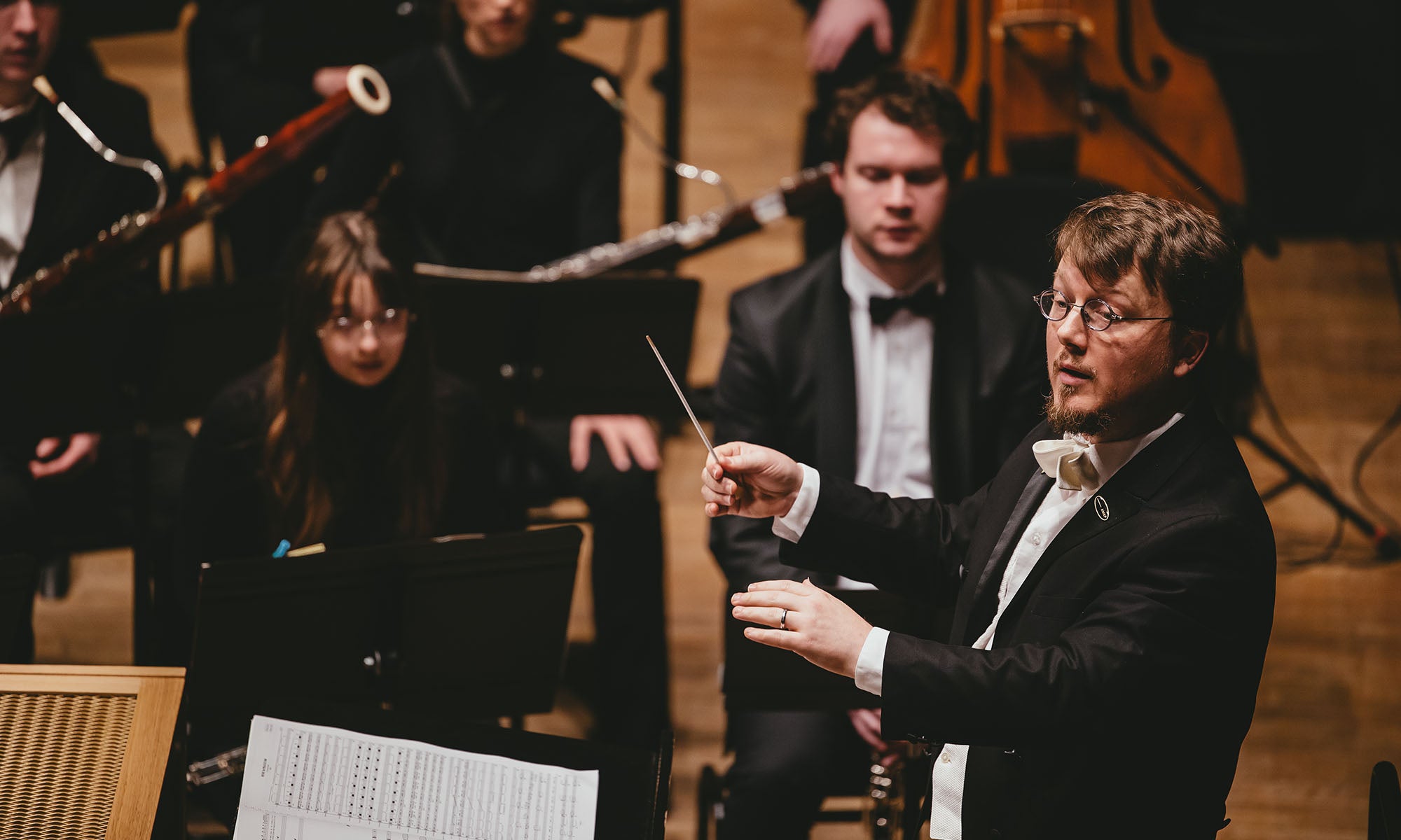A conductor leads a music ensemble.