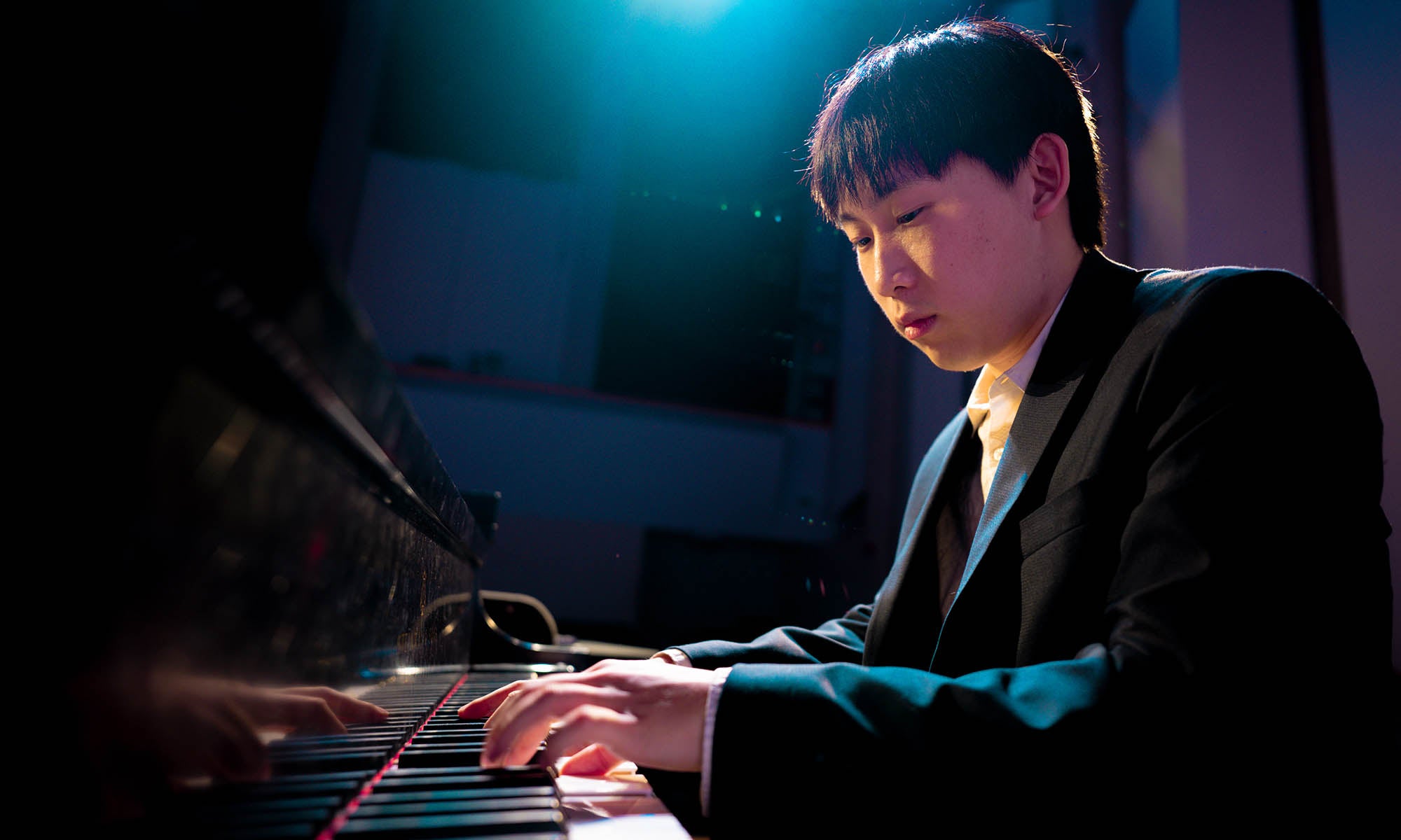 A persons playing piano on a concert stage.
