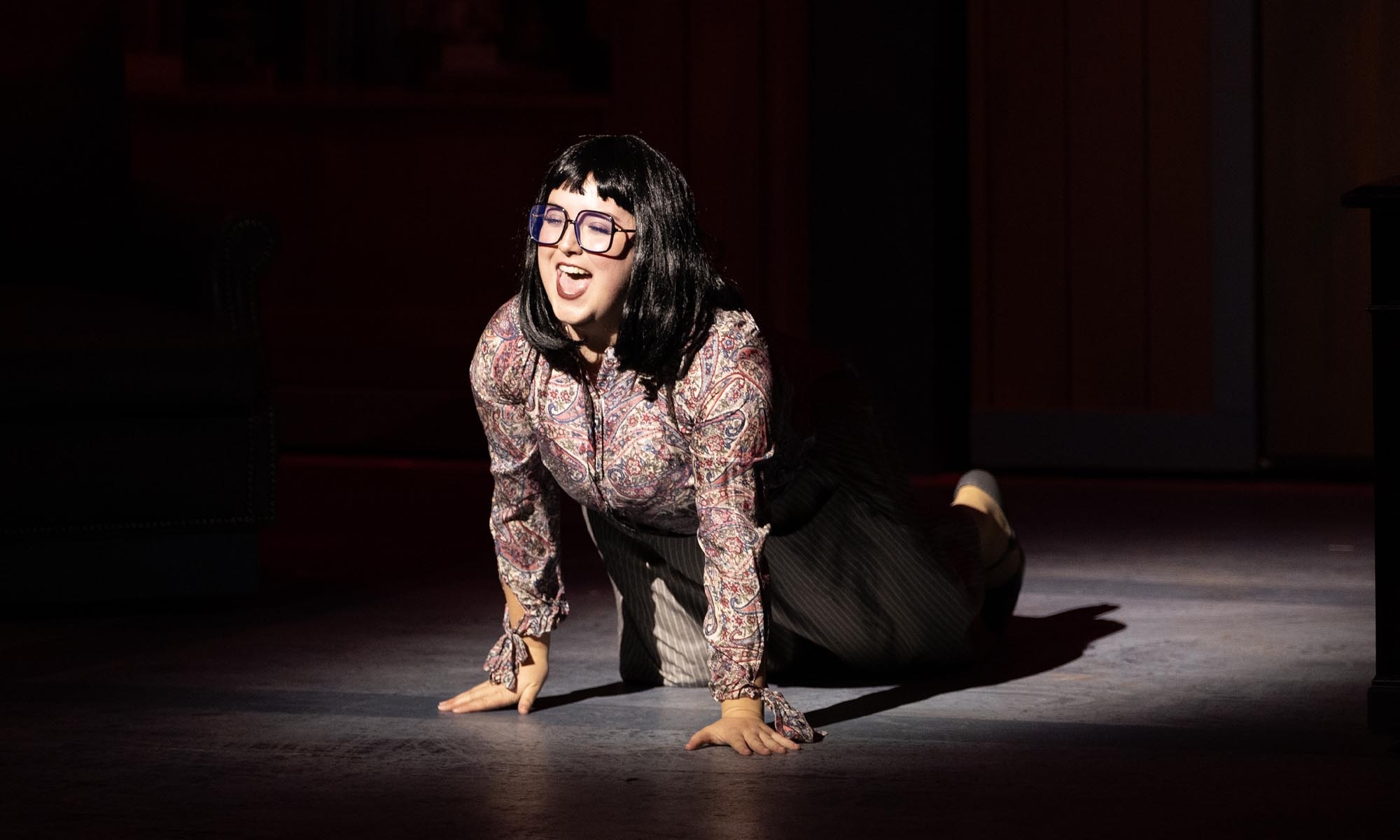A Denison Music Theatre student performs a solo in a spotlight during the musical '9 to 5.'