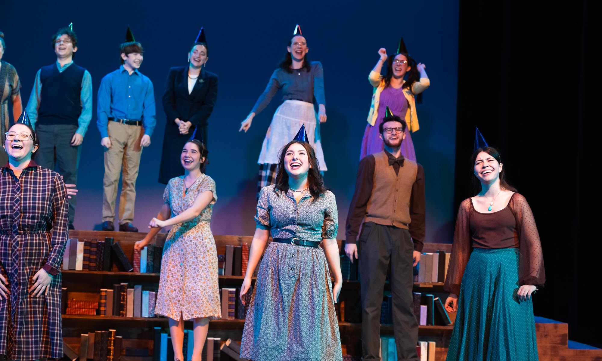 A group of Denison Music Theatre students on stage singing an ensemble number.