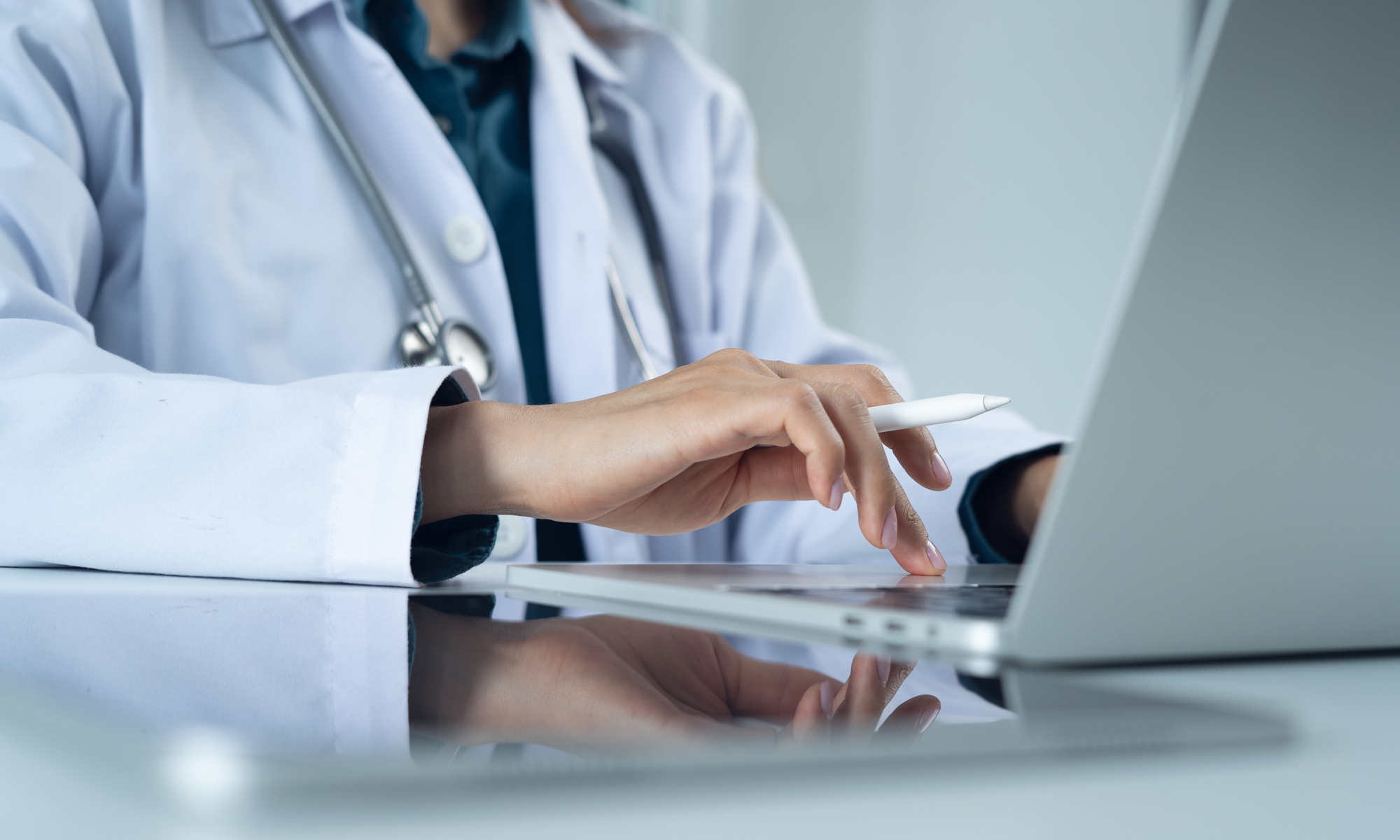 A health professional in front of their laptop.