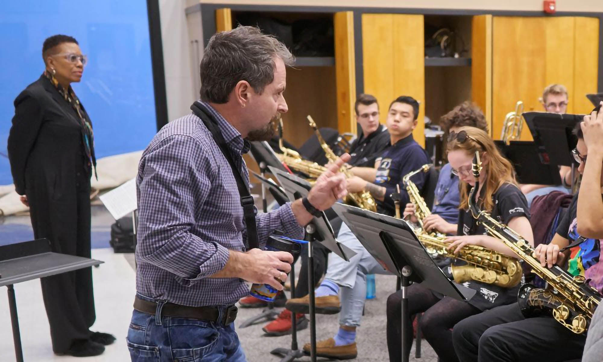 A band instructor leads a classroom band rehearsal.