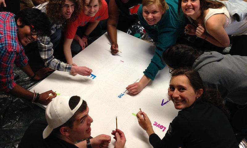 Students painting a canvas together