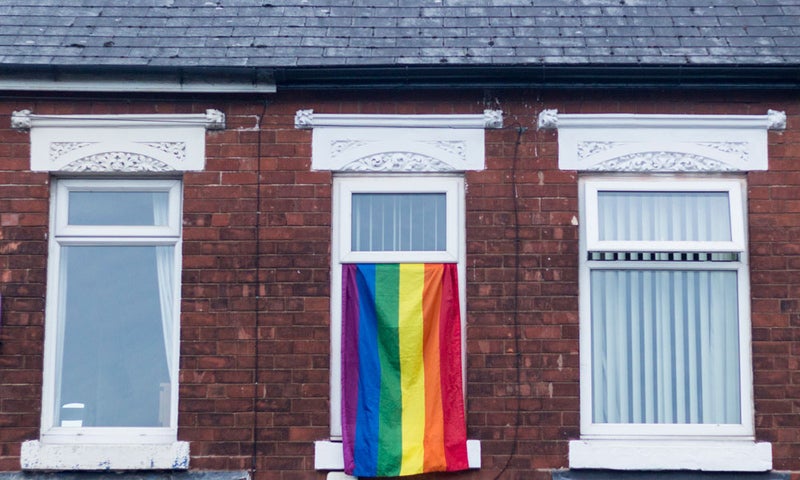 Pride flag hanging out of a window